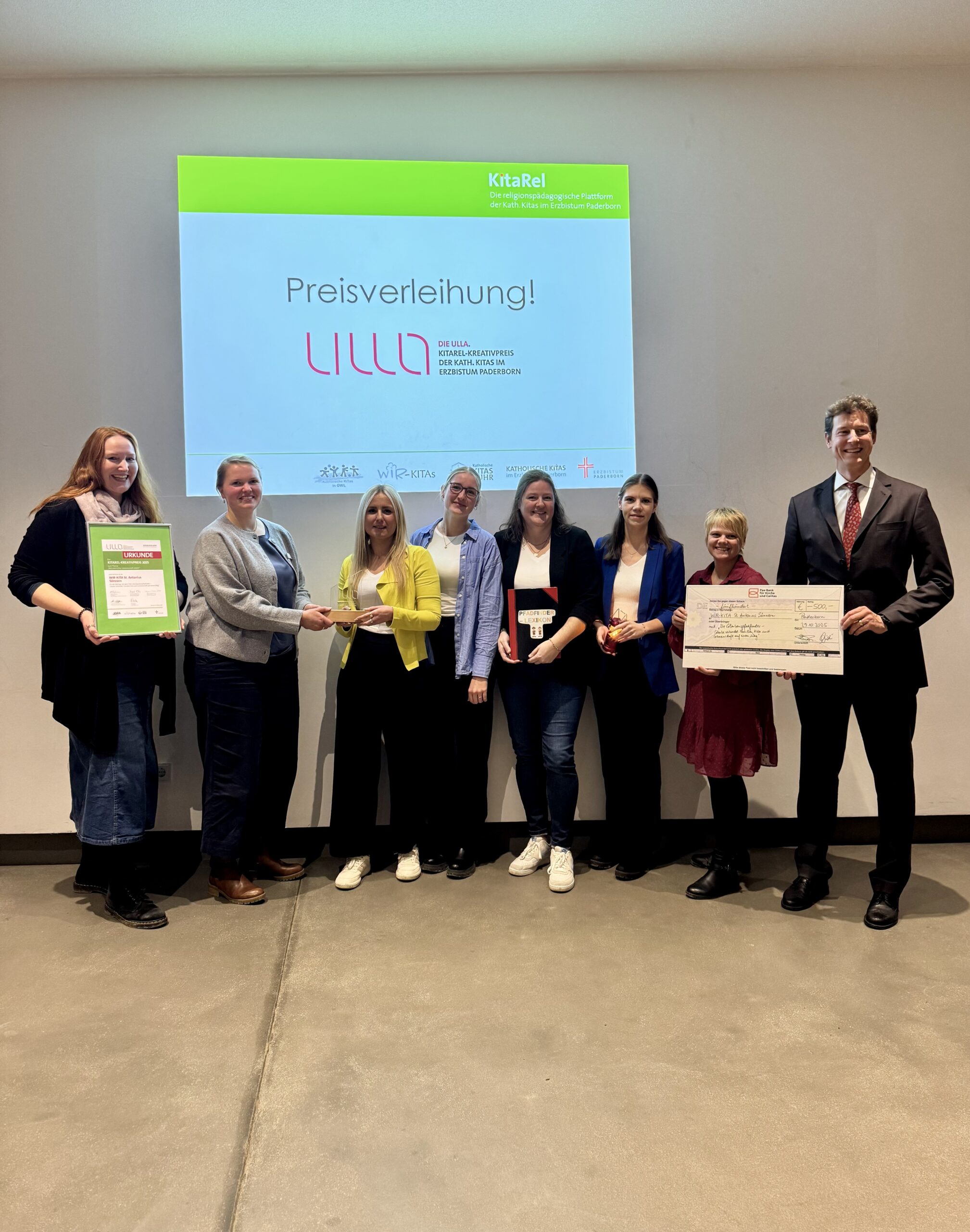 (Team der) WIR-KITA St. Antonius Sönnern mit (von links) Jurorin Kathrin Bußmann, Verleiherin Julia Brodersen-Schäfers und (rechts außen) Freiherr von Fürstenberg als Vertreter der Pax-Bank für Kirche und Caritas.