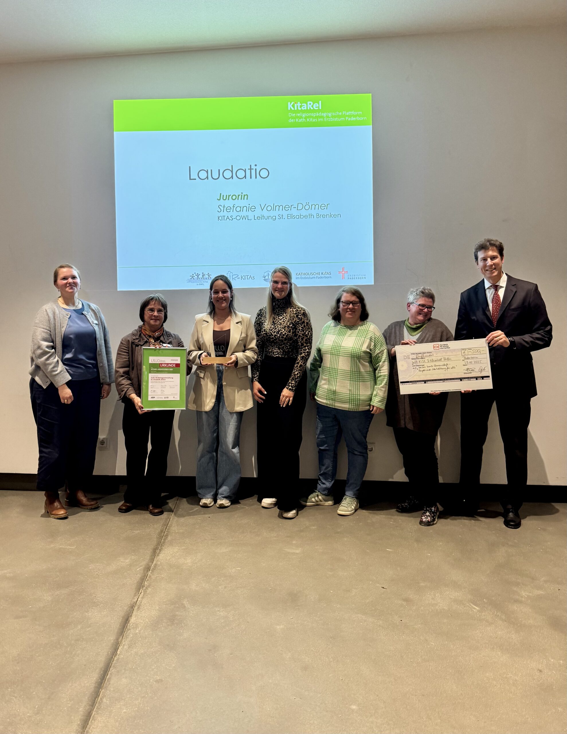 (Team der) WIR-KITA St. Elisabeth Brilon mit Julia Brodersen Schäfers und Jurorin Stefanie Volmer-Dömer (links), sowie Bank-Vertreter.